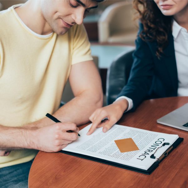 selective-focus-of-happy-man-signing-contract-near-2023-11-27-05-15-30-utc-1.jpg